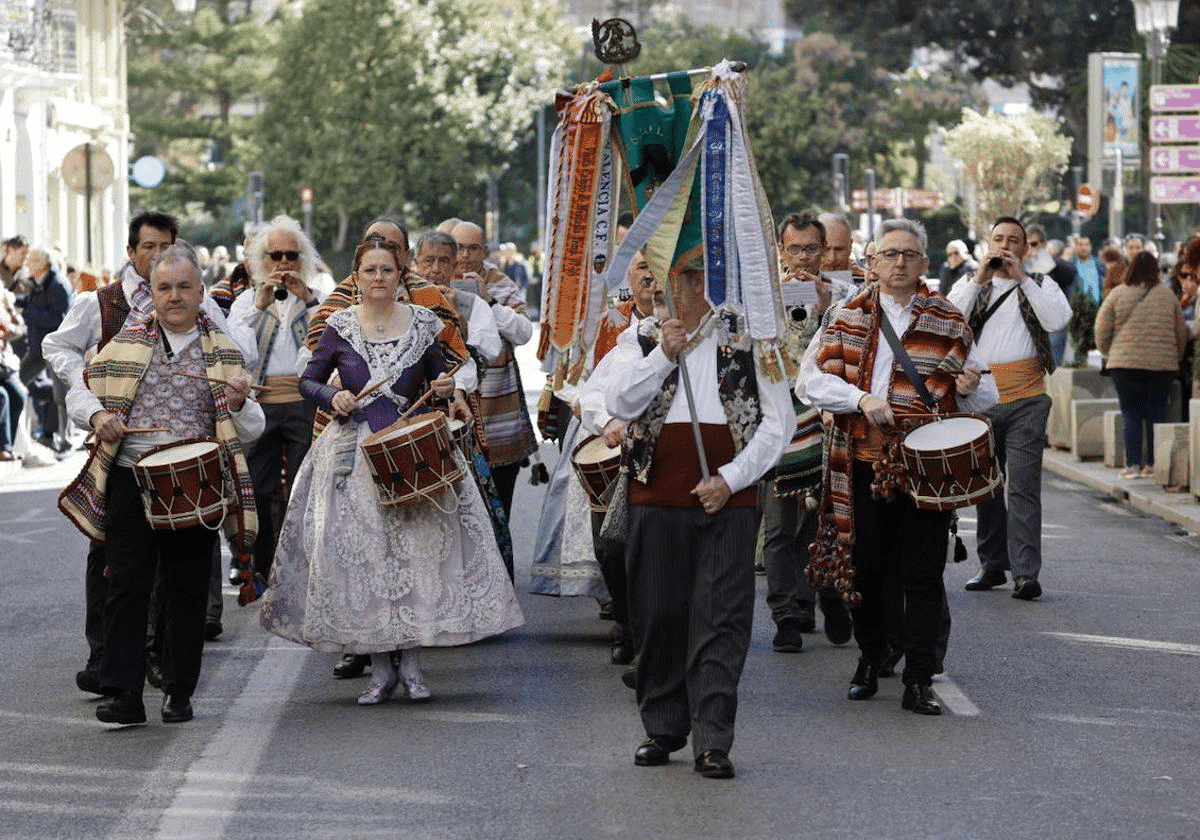 people walking the streets of valencia with flags and instruments